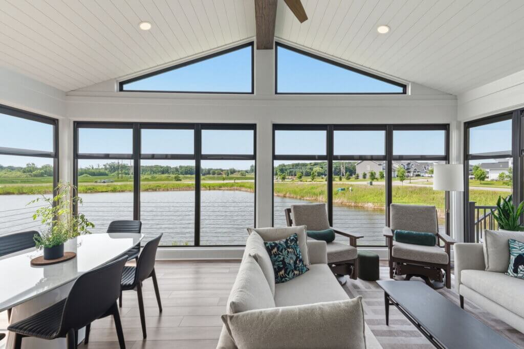 Completed three-season porch with large windows overlooking a pond.