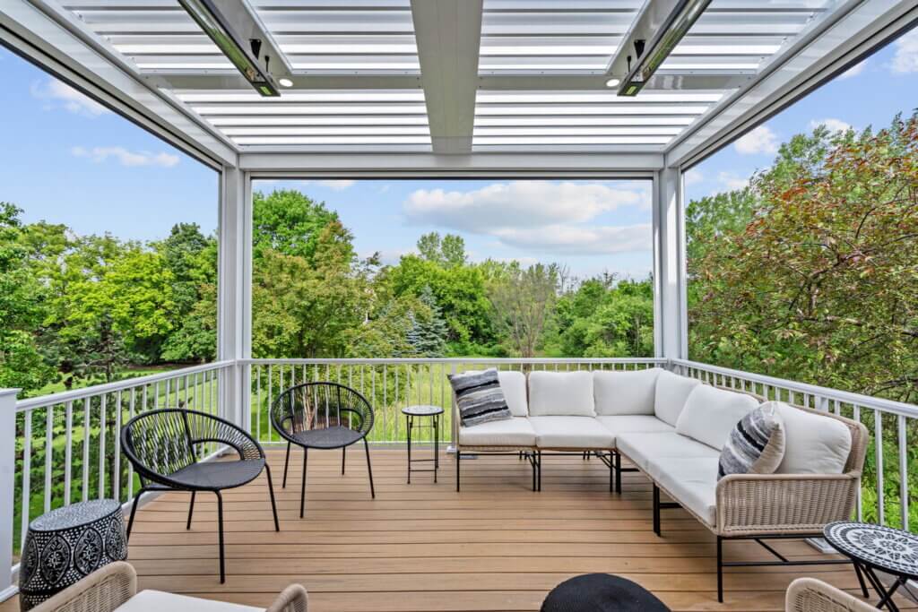 Completed deck with a white louvered roof, integrated heaters, and outdoor seating.