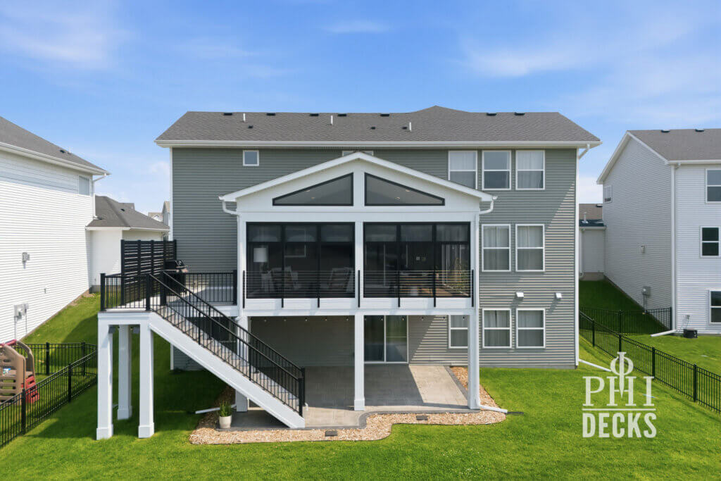 Exterior of the Pondview Porch with black windows, deck stairs, cable railing, and covered patio below.