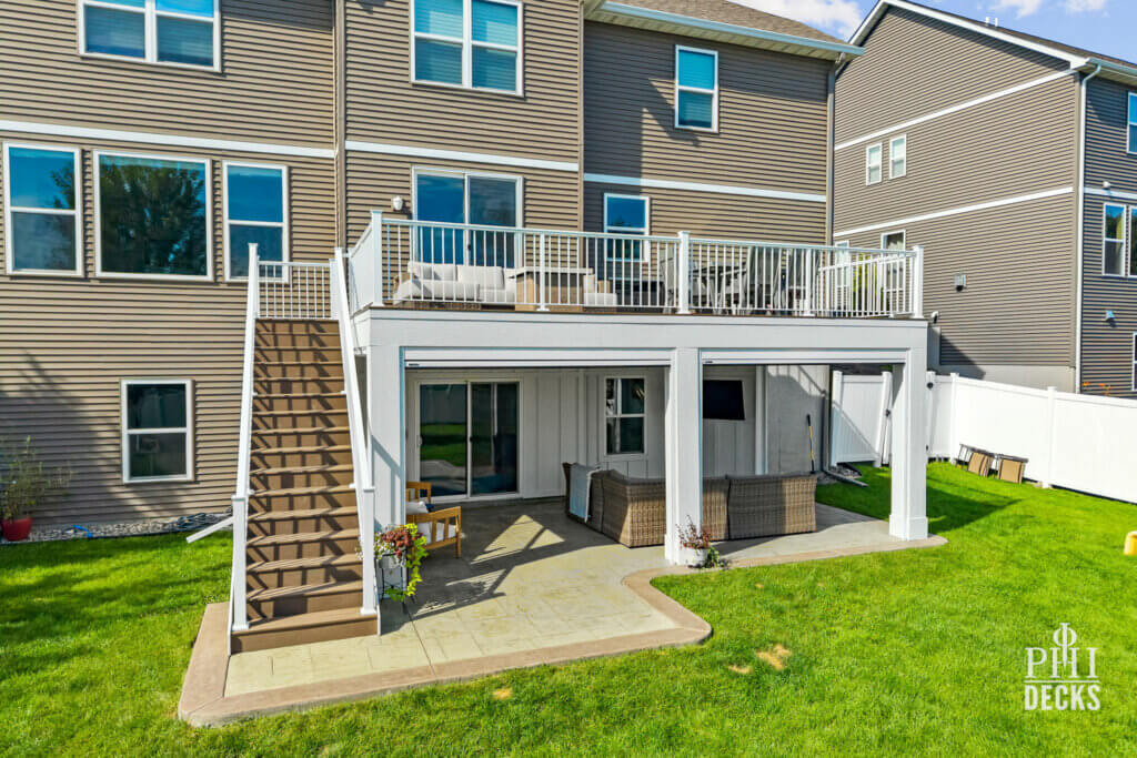 The Oakview Deck in Victoria, MN, with white railing, composite decking, stairs, and a covered outdoor living space below