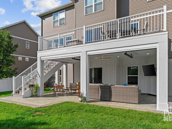 The Oakview Deck with white railing and an open covered patio with retractable screens below.