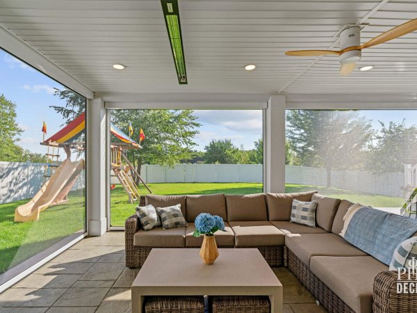 Screened outdoor living area beneath The Oakview Deck with sectional seating, ceiling fan, recessed lights, and infrared heater.
