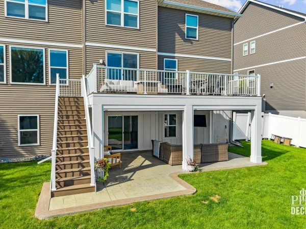 The Oakview Deck with white railing, composite decking, stairs, and a covered patio below.