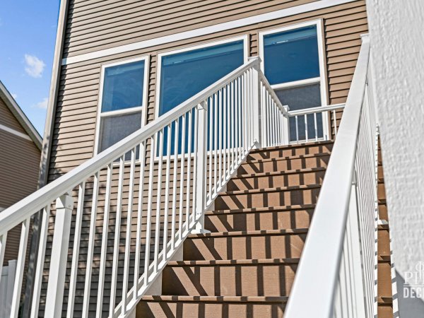 The Oakview Deck stairs with Dark Oak composite treads and white aluminum railing.