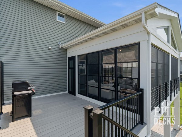 Exterior of the Pondview Porch with black Xtend windows, TimberTech deck, and black aluminum railing.