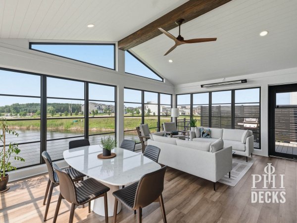 Interior of the Pondview Porch with black Xtend windows, vaulted ceiling, dining area, and pond views